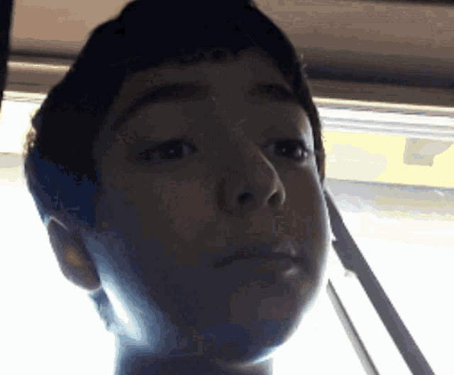 a close up of a young boy 's face with a yellow background