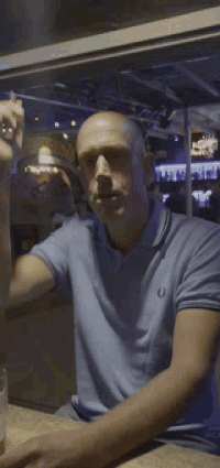 a man wearing a blue shirt with a horseshoe logo on it
