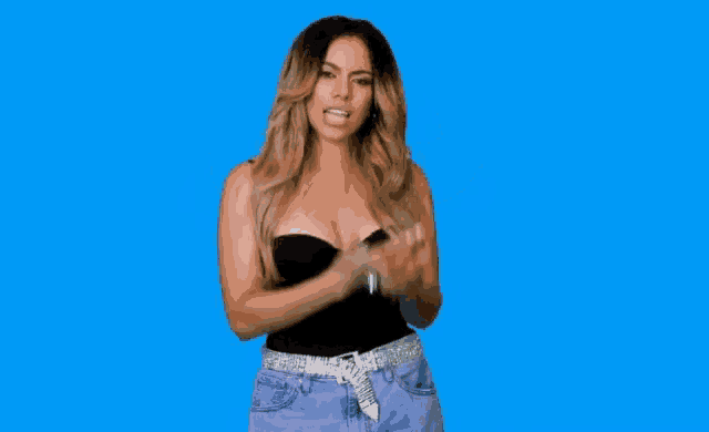 a woman in a black top and purple shorts is making a funny face .
