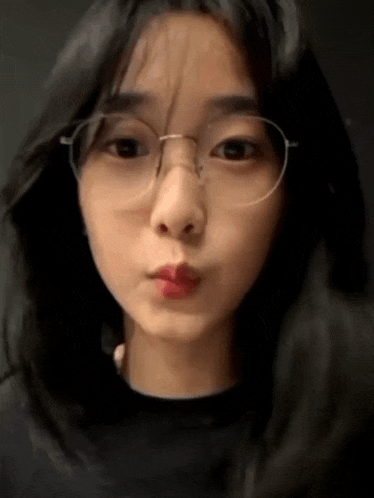 a close up of a woman wearing glasses making a funny face .