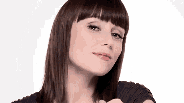 a close up of a woman 's face with a fringe on a white background .