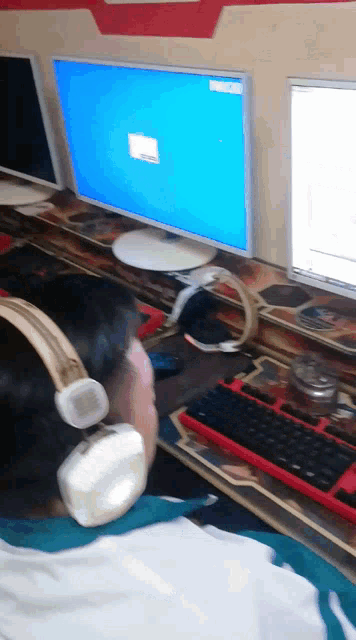 a man wearing headphones sits in front of a computer
