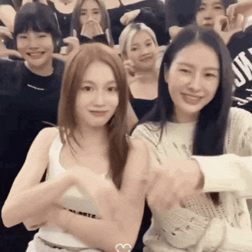 a group of young women are posing for a picture and one of them is wearing a sweater that says jm