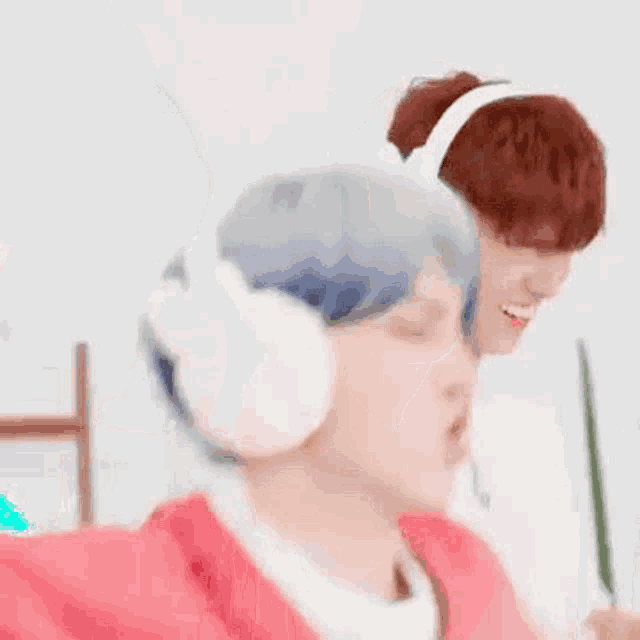 a couple of men wearing headphones and ear muffs are sitting next to each other .