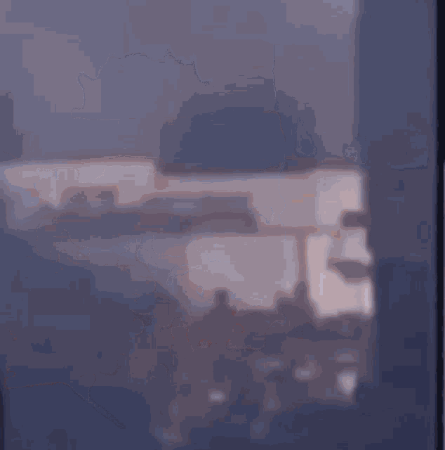 a blurry picture of a person standing in front of a window looking out .