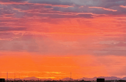 a sunset sky with mountains in the background