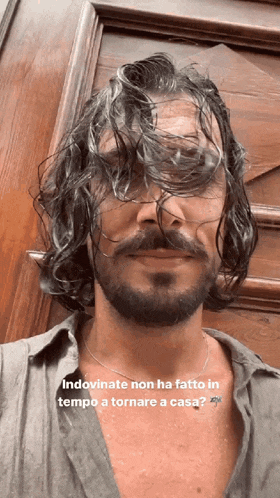 a man with long curly hair and a beard is wearing sunglasses