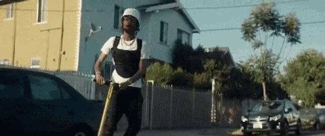 a man is riding a scooter down a city street .