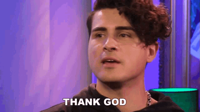 a young man with curly hair is giving a thank you gesture .
