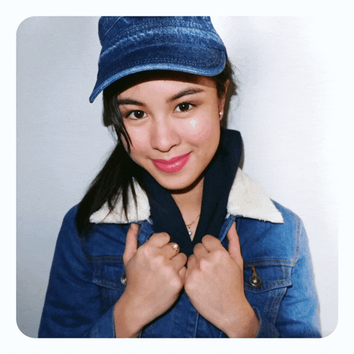 a woman wearing a hat and a denim jacket