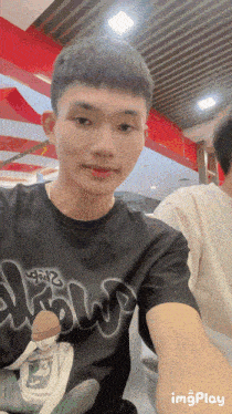 a young man taking a selfie with a black shirt that says ' draw ' on it