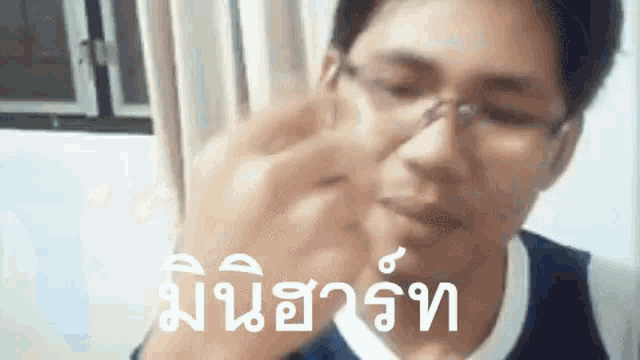 a man wearing glasses and a nose ring is holding something in his hand .