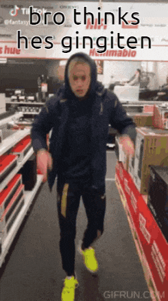 a man in a hooded jacket is dancing in a store with the words bro thinks hes gingiten written above him .