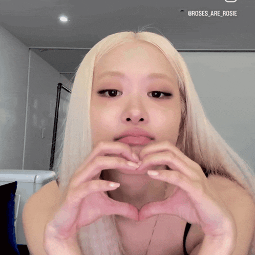 a woman making a heart shape with her hands with the name rosie on the bottom