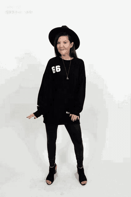 a woman wearing a black sweater with the number 66 on the front