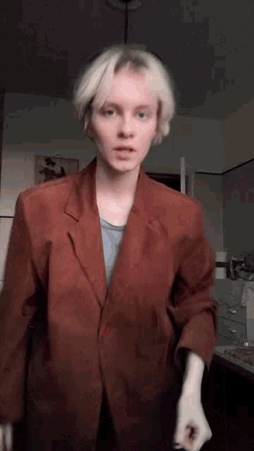 a young woman with blonde hair is wearing a red jacket