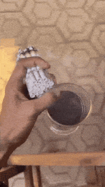 a person is pouring a drink into a cup with a straw