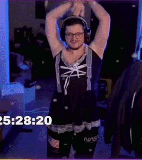 a man wearing headphones and a dress with nasa on the shorts is dancing
