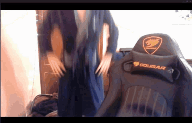 a woman is standing in front of a chair that says cougar