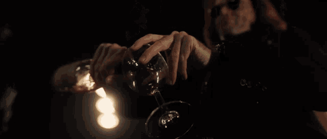 a blurred image of a person holding a glass in their hand