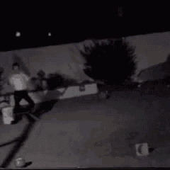 a black and white photo of a person skateboarding at night