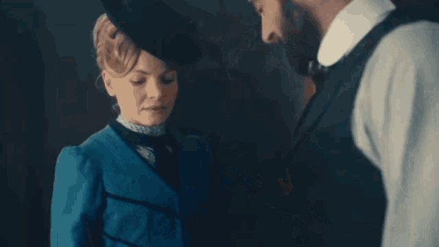 a man is kissing a woman 's hand in a dark room