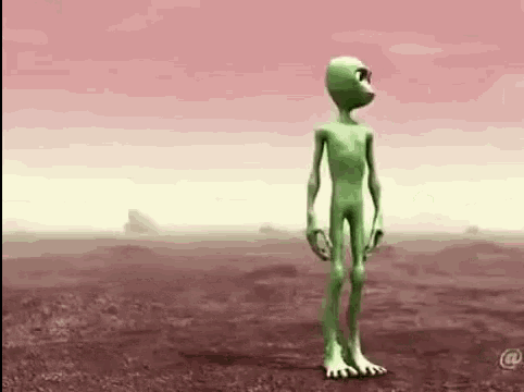 a green cartoon alien is standing in a field .