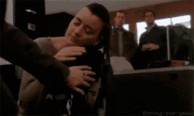 a woman is hugging a black cat in a room with the words baring-our-souls on the bottom