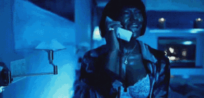 a woman is talking on a cell phone in a room with blue lights .