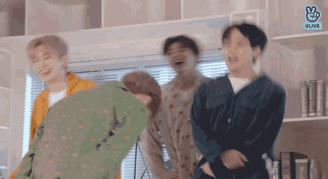 a group of young men are dancing in a room with a vlive logo
