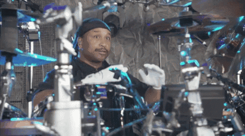 a man wearing white gloves playing drums
