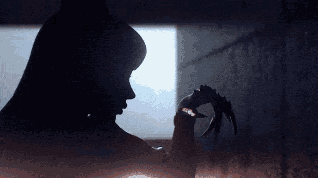 a silhouette of a woman with long hair holding a claw