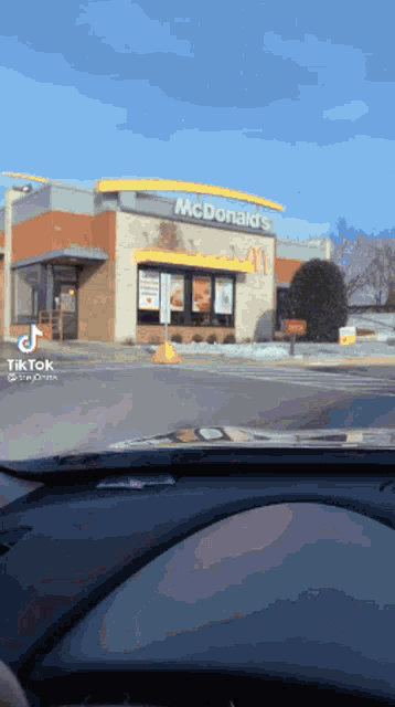 a person is driving past a mcdonald 's