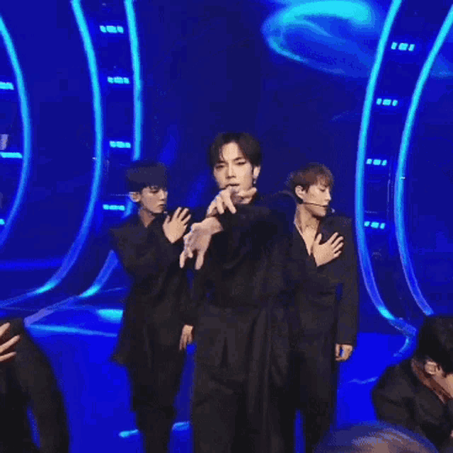 a man with a microphone in his mouth is dancing on stage