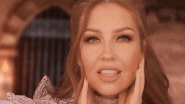 a close up of a woman 's face with her hands on it