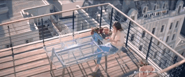 a woman sits on a rooftop balcony looking at her phone