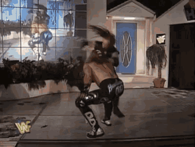 a wrestling match is going on in a room with a sign that says w on it