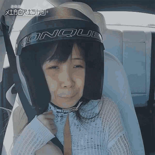 a woman wearing a helmet with the word conquest on it