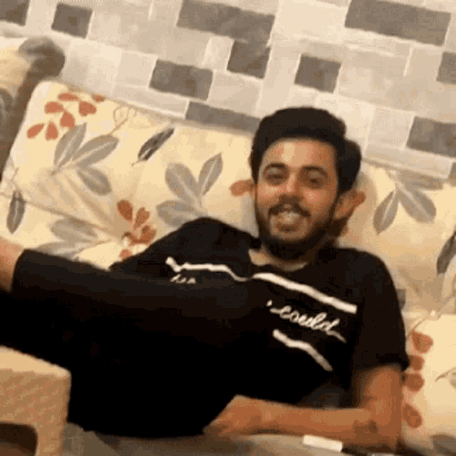 a man is laying on a couch with his feet up .