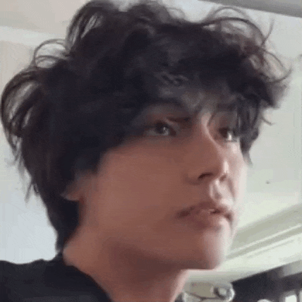 a close up of a person 's face with curly hair .