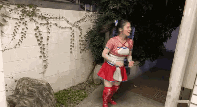 a woman in a cheerleader costume is standing in front of a white brick wall