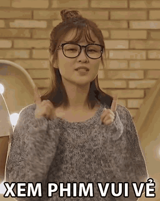 a woman wearing glasses and a grey sweater says xem phim vuive