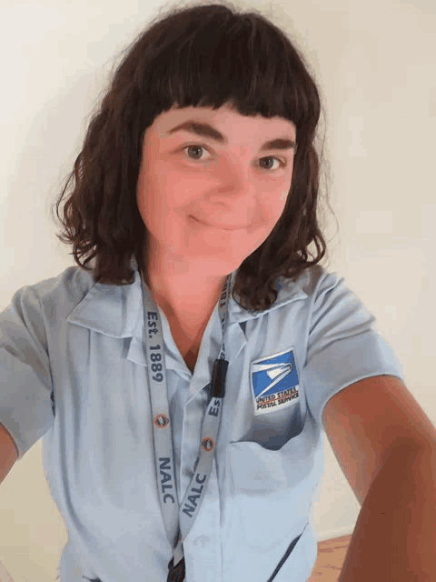 a woman wearing a blue shirt with a lanyard that says nalc on it