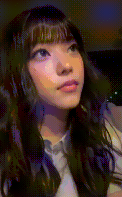 a close up of a woman 's face with long dark hair