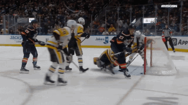 a hockey game is being played in front of a sign that says ' jakes ' on it