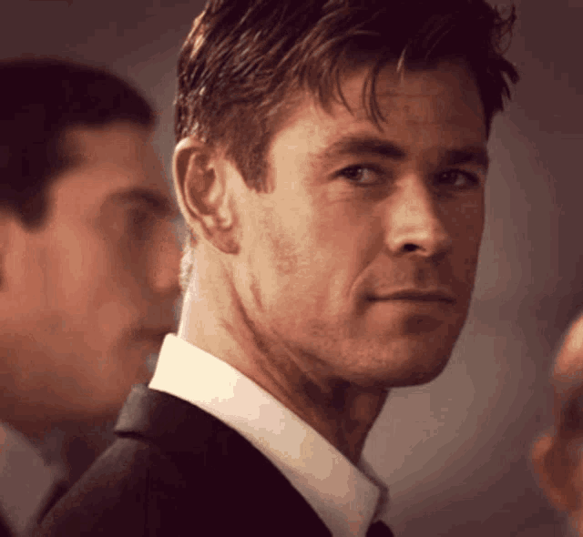 a close up of a man 's face in a suit