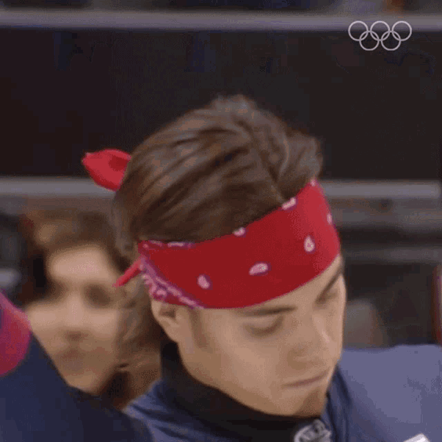 a man wearing a red headband and gloves is waving
