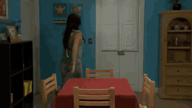 a woman is standing in front of a red table cloth