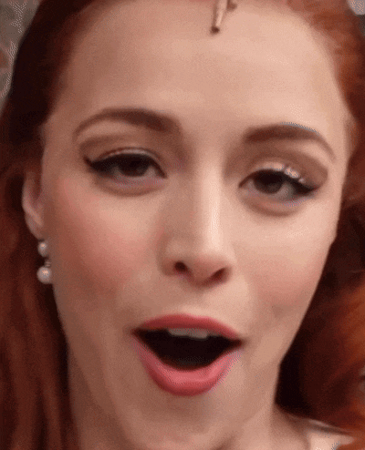 a close up of a woman 's face with her mouth open and pearl earrings