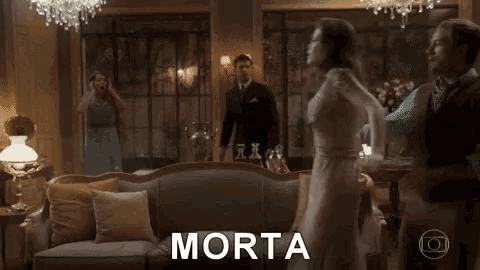 a group of people are dancing in a living room and the word morta is on the bottom right